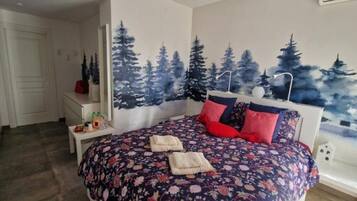 Una camera da letto con un letto, un comodino e un affresco raffigurante alberi.