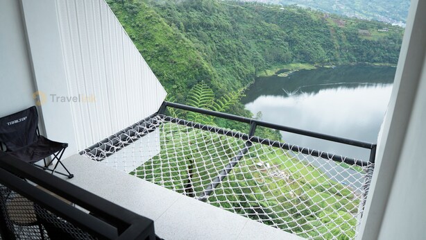 Un balcón con vista a un lago y colinas.