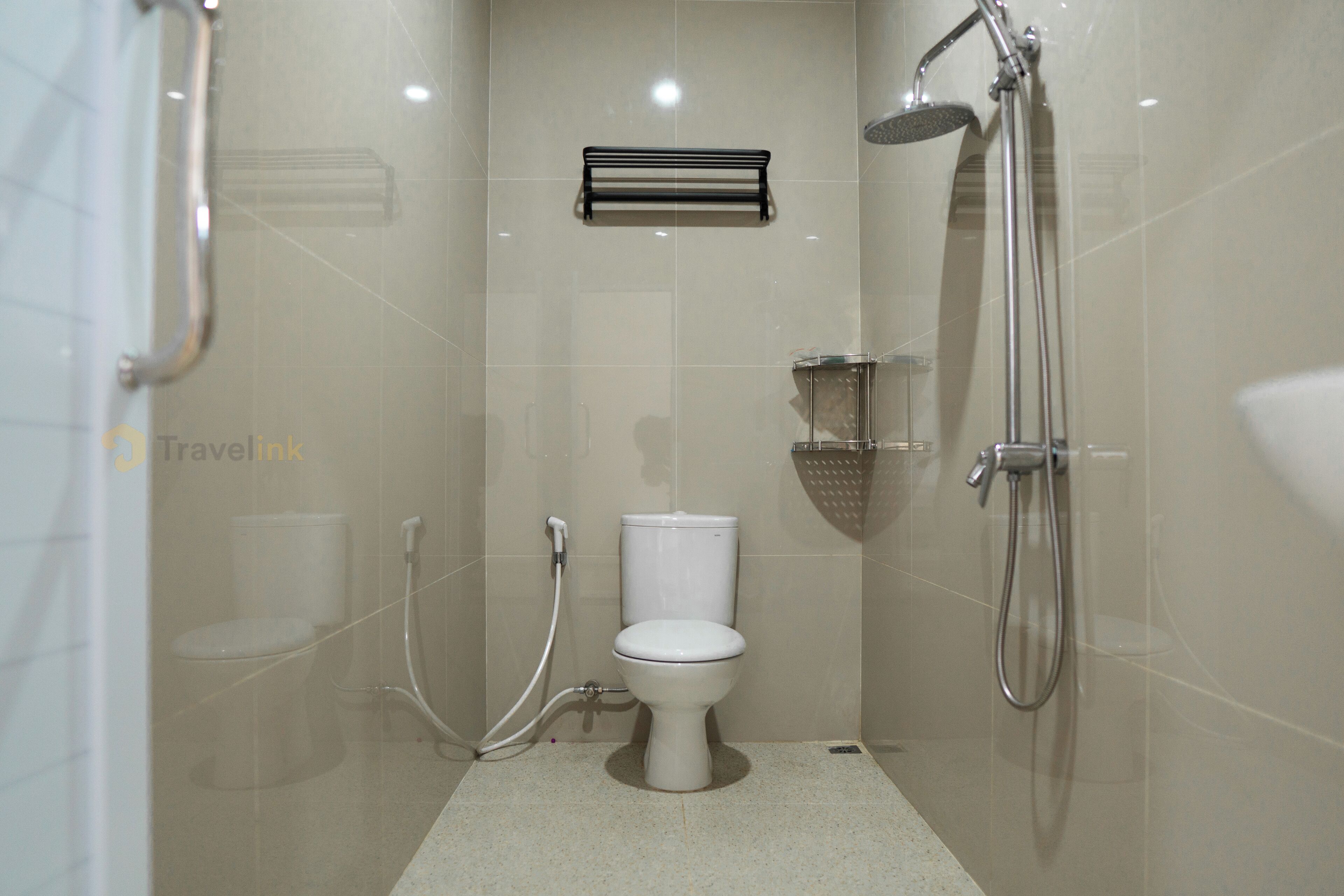 A small, modern bathroom with a toilet, a shower, and a towel rack.