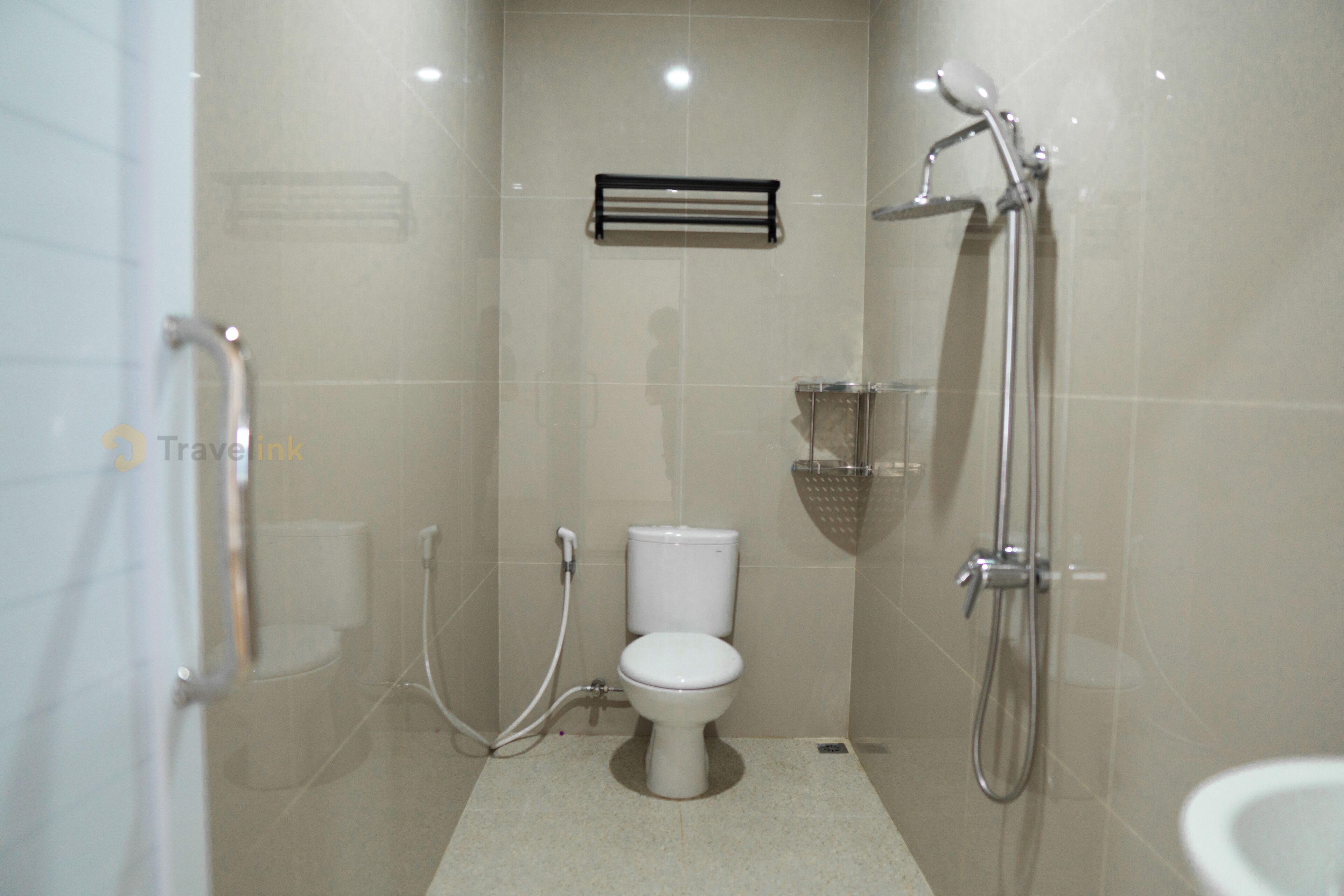Un baño moderno con inodoro, ducha y un perchero para toallas.