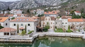 Une ville côtière avec des bâtiments en pierre, une place centrale et une étendue d’eau dans laquelle se reflète la ville.