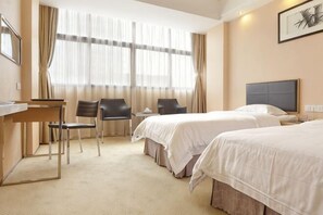 Une chambre d’hôtel avec deux lits, un bureau, des chaises et une grande fenêtre avec des rideaux.