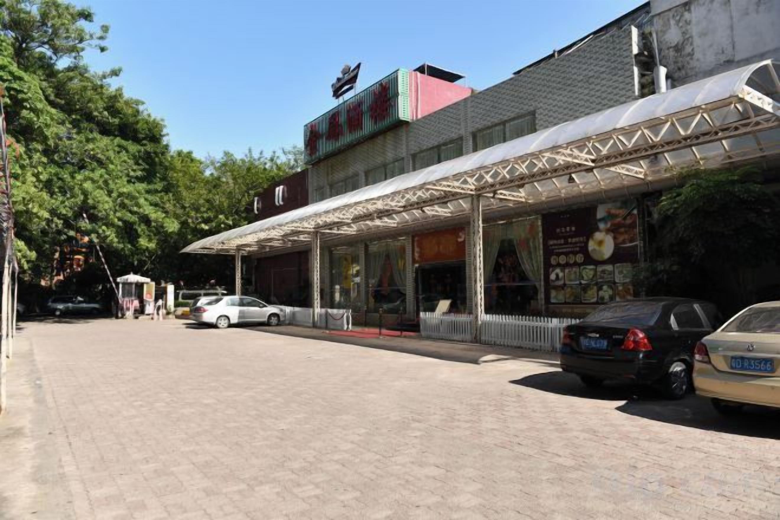 A building with a covered entrance and a signboard.