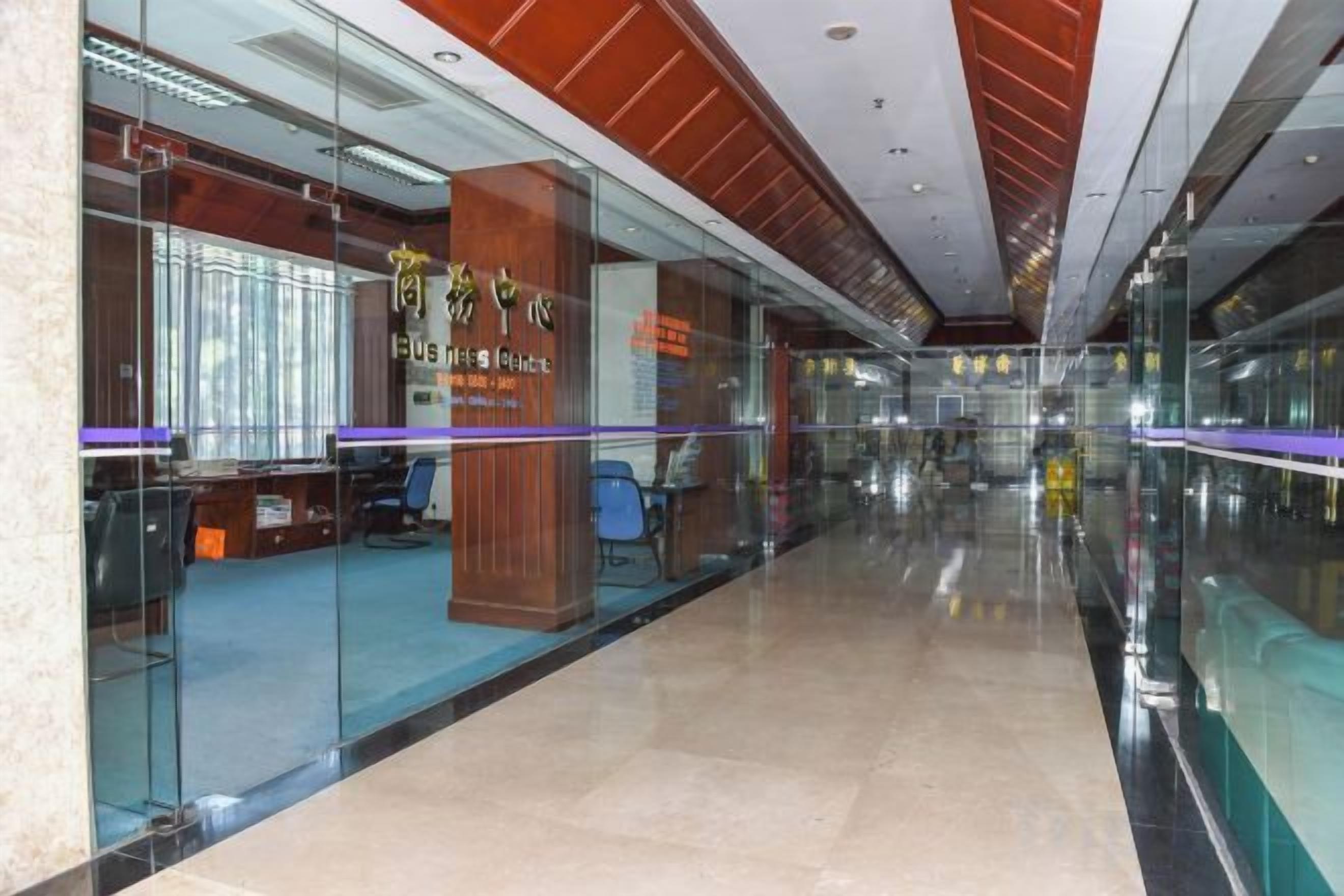 A modern interior with glass partitions, a reception area, and a polished floor.