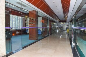 A modern interior with glass partitions, a reception area, and a polished floor. - Swatow Peninsula Hotel (Shantou)