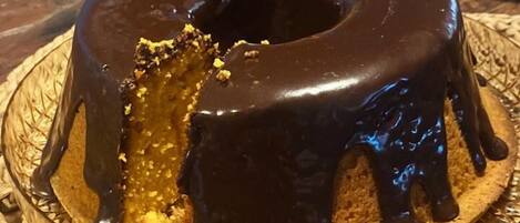 A chocolate-glazed bundt cake on a woven placemat.