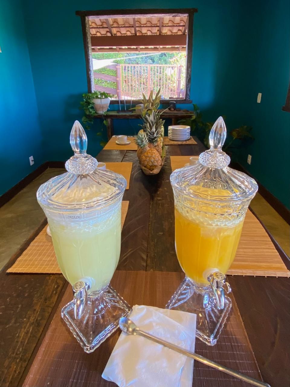 Two glass containers with lids on a wooden table, each with a spoon and napkin.