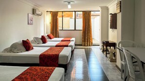 A hotel room with three beds, a small table, a chair, and a television. - GRAN HOTEL CALI  (Cali)