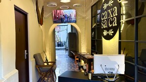 A narrow hallway with a patterned floor, a desk with a computer, and a sign reading "Casa Salca". - Casa Xaca (San Miguel de Allende)