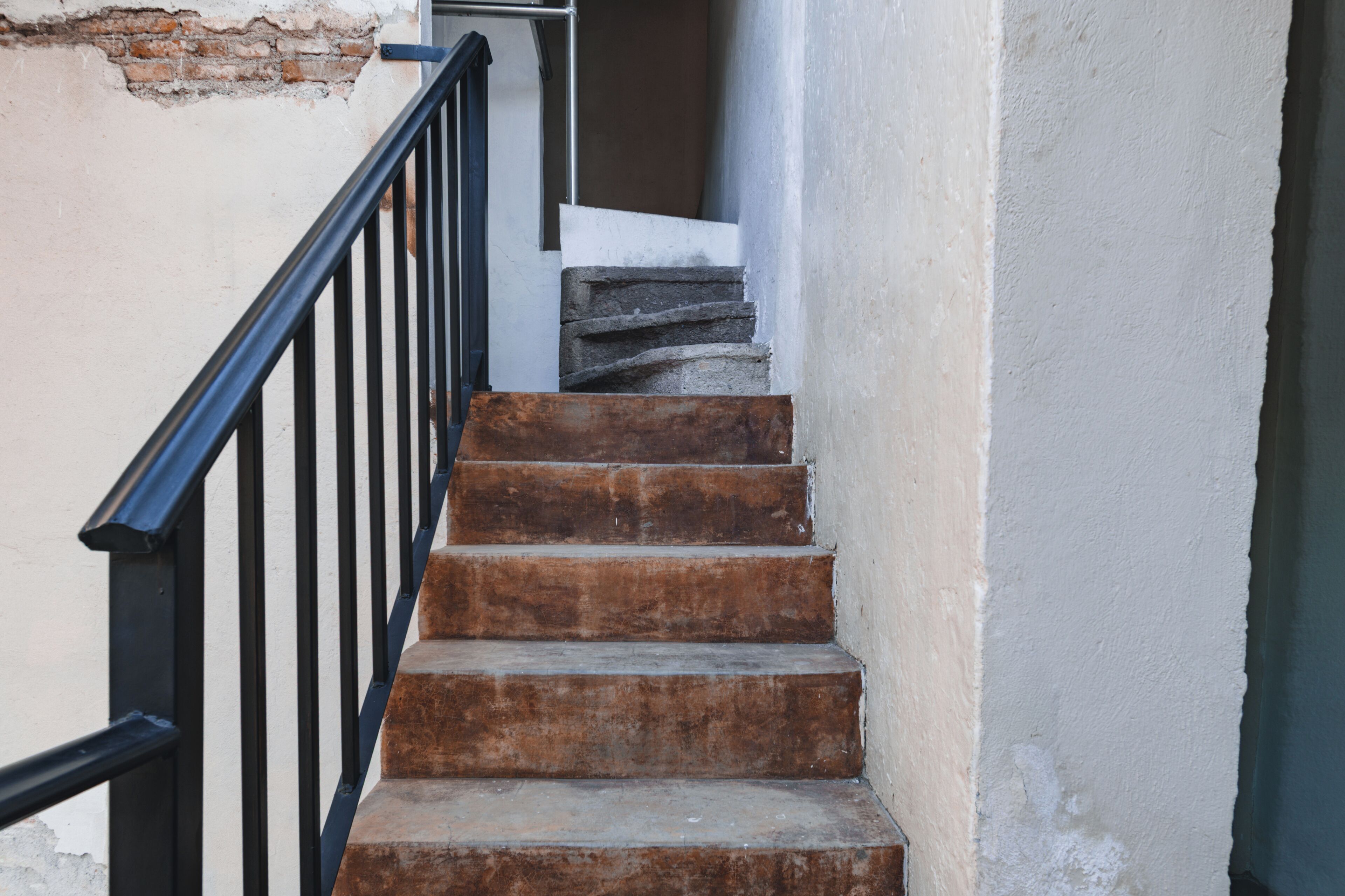 A staircase with a metal railing leading to a landing.