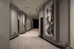 A corridor with framed artwork on the walls, recessed lighting, and a polished floor. - Aksu Hongfu Hotel (Aksu City)