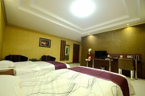 Une chambre d’hôtel avec deux lits, un bureau, une chaise, une télévision et un téléphone.
