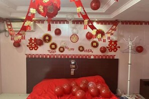 A room with a bed, red and white decorations, and a ceiling fan. - City 118 Hotel (High-speed) (Gaoyi)