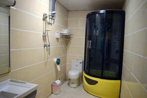 Une petite salle de bain comprenant des toilettes, un lavabo et un espace douche.