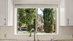 A kitchen with a window, a sink, and a bottle of dish soap. - Desert View Studio with Patio & Red Rock Trails (Sedona)