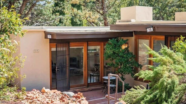 A modern house with a glass door entrance, a patio area, and a small garden with rocks and plants. - Desert View Studio with Patio & Red Rock Trails (Sedona)
