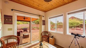 A room with a patio area, a telescope, and a view of the desert landscape.