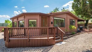 A two-story cabin with a wooden deck and a covered porch.