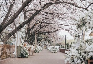 Un sentier bordé d’arbres couverts de neige et d’une clôture blanche, qui mène à un bâtiment doté d’une entrée abritée.