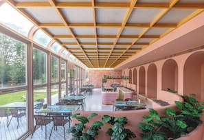 Un espace de restauration intérieur avec des tables, des chaises et un comptoir de bar.