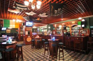 A bar with stools, a counter, and a checkered floor.