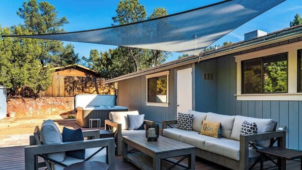 Un patio al aire libre con un sofá, sillas y una mesa.