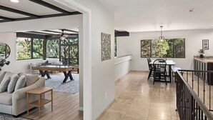 Amplia sala de estar con sofá, mesa de centro y mesa de comedor. Un ventanal grande ofrece vistas al exterior.