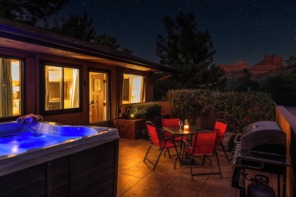 A hot tub, outdoor seating, and a grill area at a hotel.