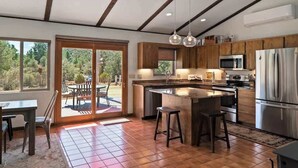 Una cocina moderna con una isla grande, electrodomésticos de acero inoxidable y armarios de madera.