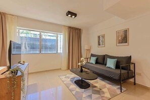 Relax in this stylish living room with a sofa, coffee table, and floor rug, surrounded by framed artworks and a small plant.