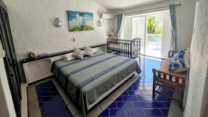 A bedroom with a bed, a ceiling fan, a window with curtains, and a view of the outdoors. - OCEAN VIEW PENTHOUSE WITH TERRACE (Manzanillo)