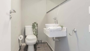 A modern bathroom with a toilet, sink, and shower. - MOT Rentals + GuateFlat 'G' 2 Bd in Palermo Soho (Buenos Aires)