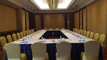 A conference room with a long table, chairs, and a microphone.