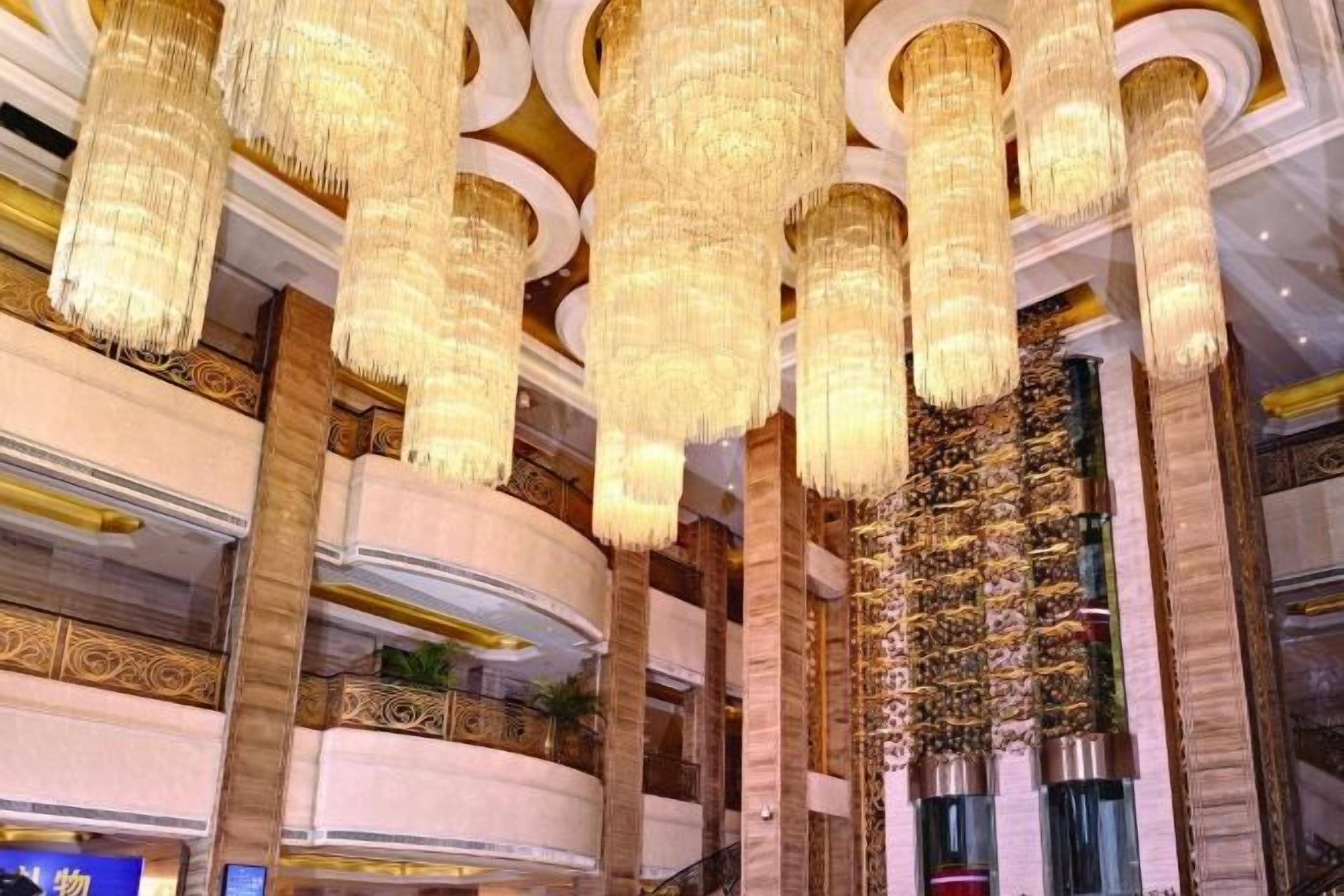 Un vaste hall d’entrée agrémenté de lustres somptueux, doté d’un plafond haut et d’un décor intérieur luxueux.