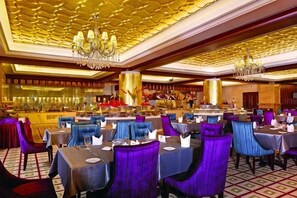 A hotel dining area with tables and chairs, a bar, and a chandelier. - Rui'er Hotel (Chongqing)
