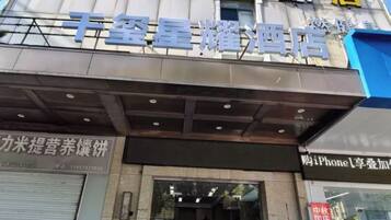 A hotel entrance with a sign above the door and a storefront with a sign above it.
