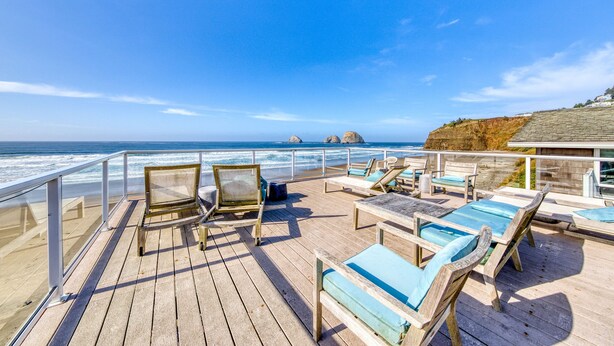 A wooden deck with lounge chairs and a glass railing overlooking the ocean. - Oceanside Inn #6: Pet-free unit. No pets allowed. (Oceanside)