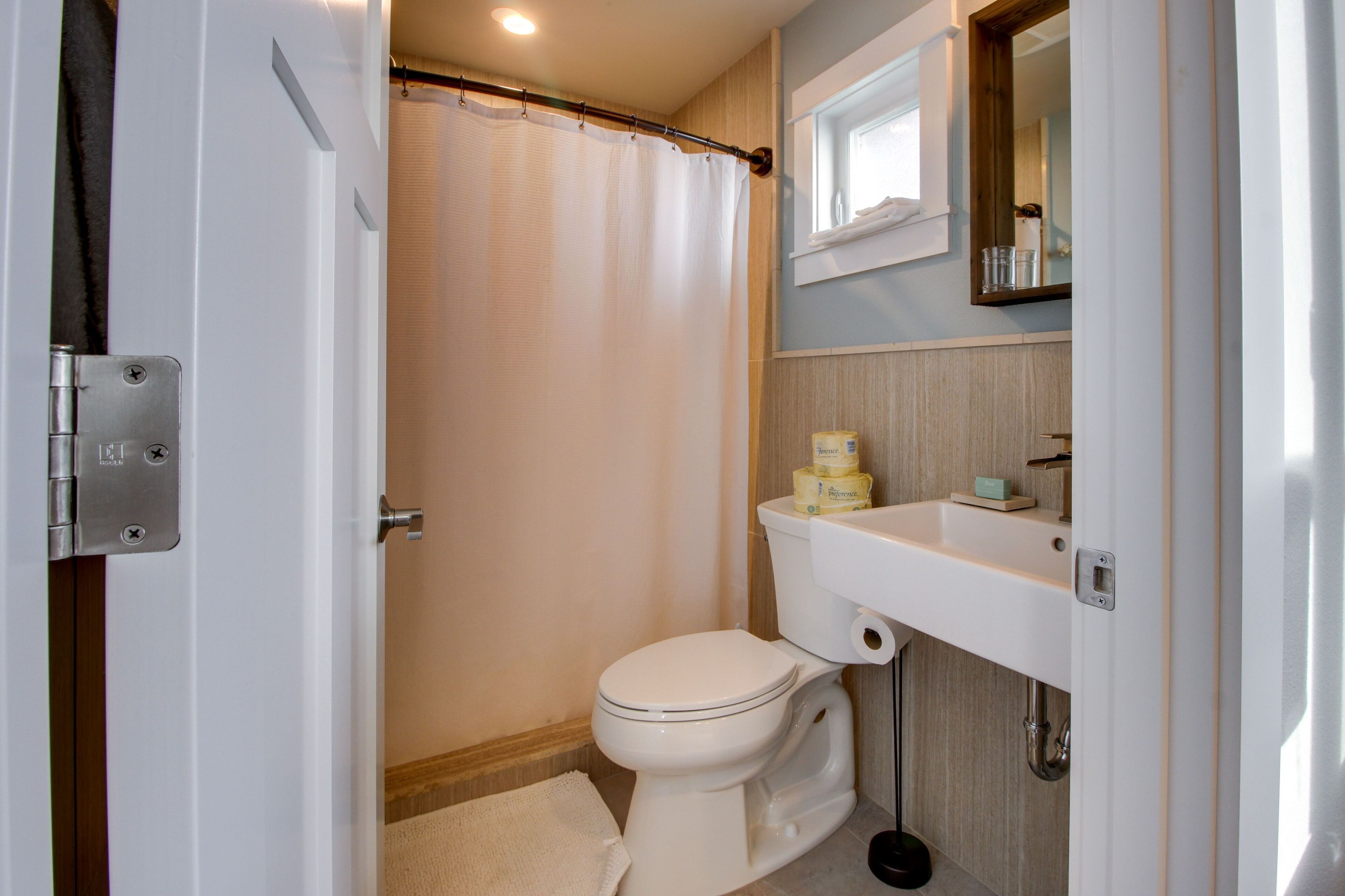 A bathroom with a toilet, sink, and shower curtain.