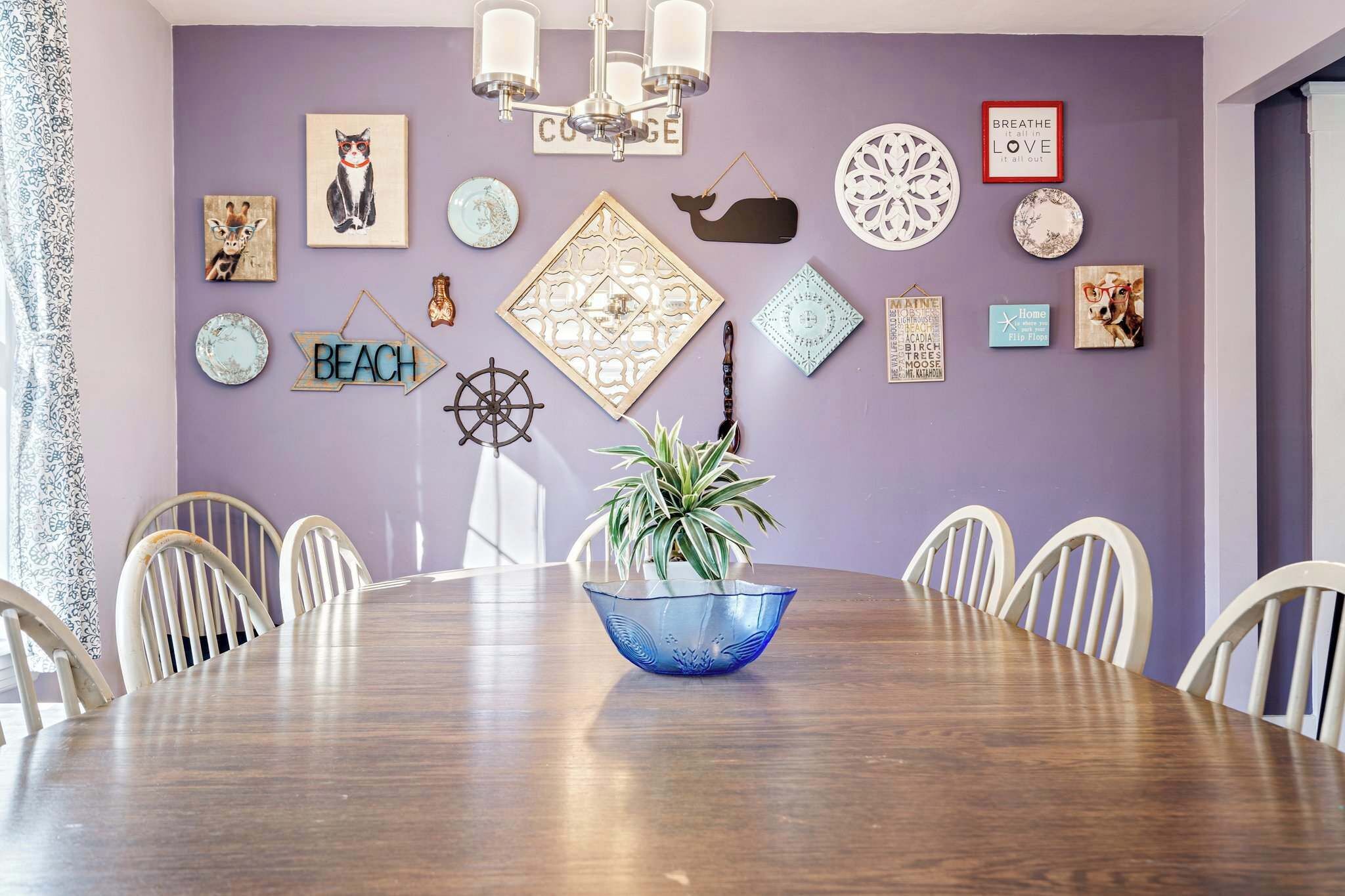 A dining area with a round table, chairs, and a blue decorative bowl.