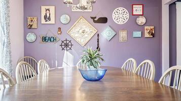 A dining area with a round table, chairs, and a blue decorative bowl.