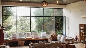 Amplia sala de estar con un ventanal grande, muebles de madera y un rincón de descanso acogedor.
