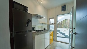 A compact kitchen with a refrigerator, stove, and sink.