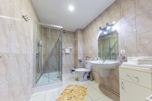 A modern bathroom with a glass-enclosed shower, a toilet, a sink, and a vanity with a mirror. - Hotel Amphitryon Premium (Bucharest)