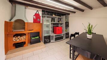 Una cucina moderna con forno a incasso, un contenitore portaoggetti rosso e un'area pranzo con tavolo e sedie neri.