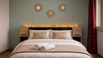 A neatly made bed with a headboard, two bedside tables, and a wall with decorative circular mirrors.