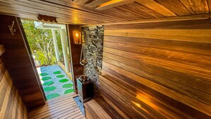 Un couloir intérieur aux murs en bois, avec un mur en pierre et un petit radiateur.