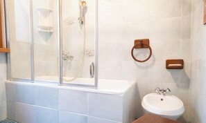 A bathroom with a glass-enclosed shower, a sink, and a toilet.