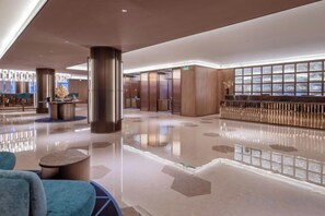 A spacious lobby with a reception desk, elevators, and a seating area. - Crystal Orange Changsha IFS (Changsha)
