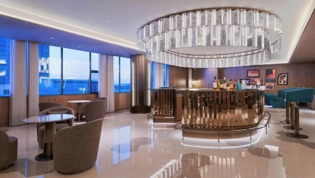 A modern hotel lobby with a bar area, seating arrangements, and large windows offering a view. - Crystal Orange Changsha IFS (Changsha)
