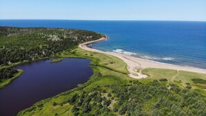 An aerial view of a coastal area with a lake, beach, and forested land. - The Lookout - Executive Class, Accessible Mini Villa (Colindale)